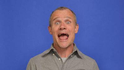Flea's cozy living room is a treasure trove of '70s style – his statement sofa, natural wood shelving, and record storage embody the trending era