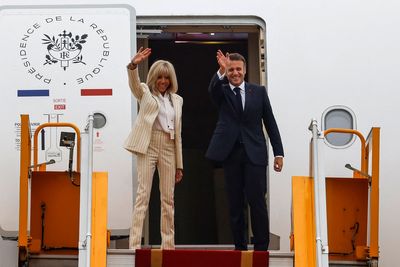 Emmanuel Macron and wife Brigitte all smiles and hand holding as they board plane after shove video
