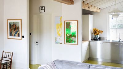 Stainless steel cabinets, retro lighting, and a bright yellow floor transformed this tired 1960s apartment kitchen into the most 'effortlessly cool' Parisian-inspired space