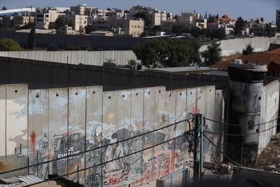 ‘I lost both legs’: Palestinians scale separation wall for chance to work