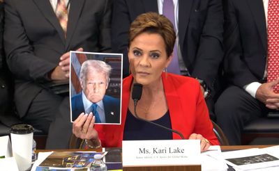 Trump Official Holds Up Trump's Picture After Being Questioned Over Hundreds of Job Cuts to Her Agency