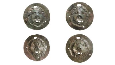 'Puzzling' bronze discs adorned with lion heads discovered in Roman-era grave