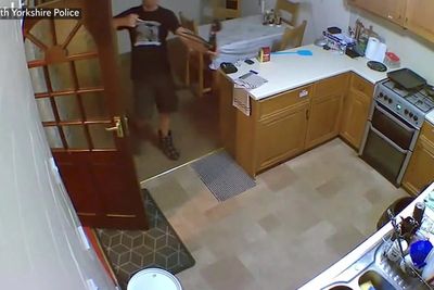 Husband prepares bow and arrow in kitchen before attacking wife