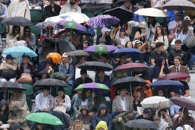 Spectators queue in ponchos as rain threatens to dampen sixth day of Wimbledon