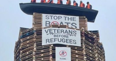 Calls for removal of migrant effigies in boat placed on loyalist bonfire