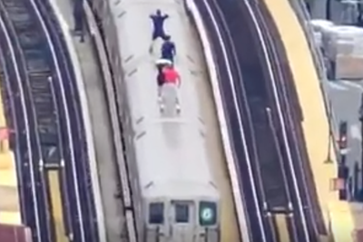 Drone footage shows teenagers riding on top of subway train