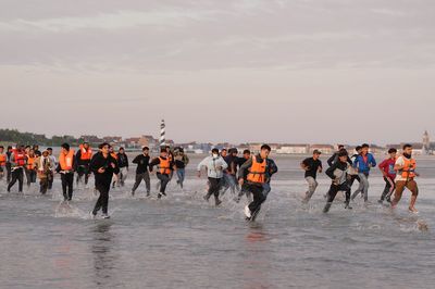 Migrants run across beach to board dinghy in the Channel