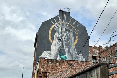 A new mural in France shows the Statue of Liberty covering her eyes in a swipe at Trump