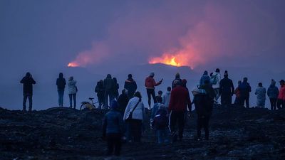 Tourists watch cooling lava as Iceland’s volcanic activity slows