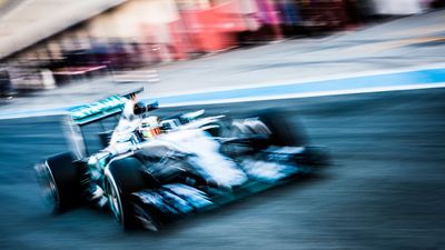 This vibrant action shot of Lewis Hamilton, captured creatively at 1/10 sec with a Nikon DSLR camera, showcases the dynamic energy of Formula 1 racing