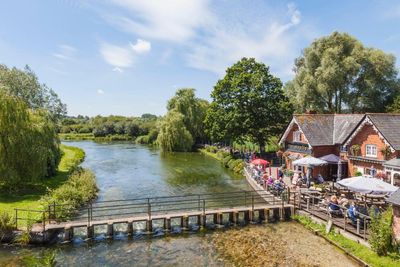 ‘Sipping a pint while trout splashed in the river on a perfect summer’s day’: readers’ favourite UK waterside pubs