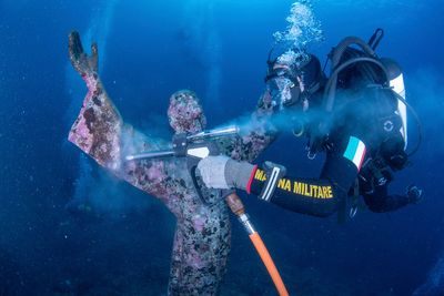 Italian divers water-blast the popular underwater statue of Christ off Portofino