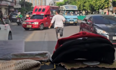 Young man clears path for rescue van on busy Bangkok road