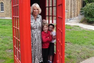 Queen bundles into phone box with schoolchildren as she visits gallery