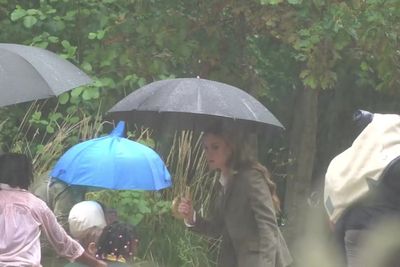 Sweet moment Kate shields schoolchildren during rain as she debuts blonde hair