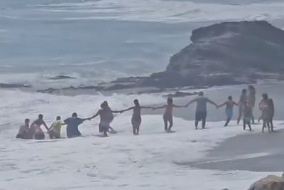 Beachgoers form human chain to save boy from being swept out to sea