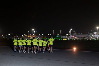 Joggers take off along runway in night-time airport fun run