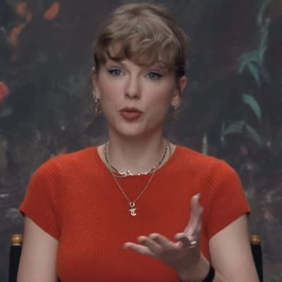 Taylor Swift Styles a Showgirl Orange Reformation Sweater With a Versace Leather Mini Skirt