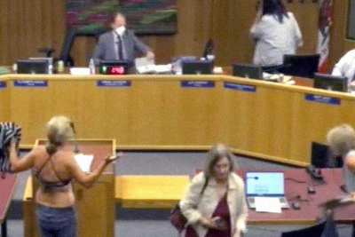 Activist strips down to a bikini during school board meeting in protest over bathroom policy for trans students