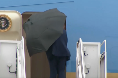 Trump struggles to take down umbrella during storm as he heads to Middle East