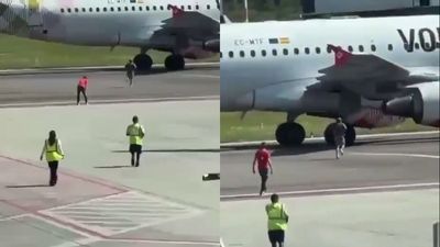 Man breaks through airport security and runs toward a plane. Staff chase him but he throws himself into the jet engine
