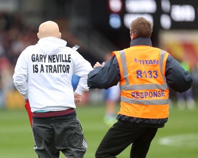 Pitch invaders disrupt League Two game in ‘Gary Neville is a traitor’ flag protest