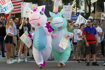 Silly inflatable costumes are taking over anti-Trump protests. What are they actually saying?