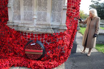 Queen Camilla jokes with volunteers as she visits huge war memorial display