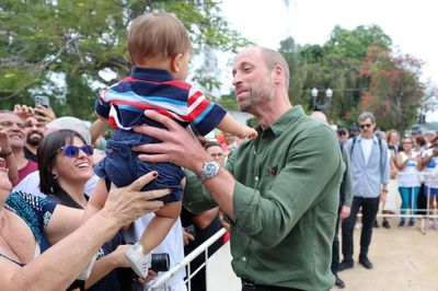 William cuddles baby as he samples island life on trip to Brazilian retreat