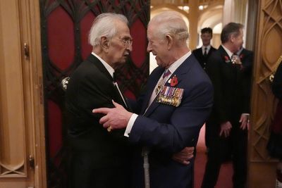 King hugs Second World War veteran, 105, at Windsor remembrance reception