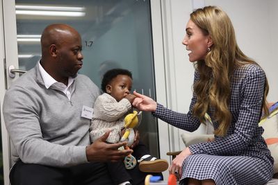 Sweet moment baby clings to Kate during visit to children’s mental health charity