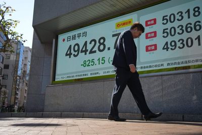 US futures slip and Asian stocks are mixed, while oil prices surge more than $1 a barrel