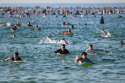 A sunrise crowd gathers at Bondi Beach in solace and defiance after a massacre