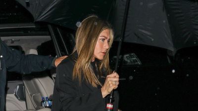 Jennifer Aniston proves white trainers are still a winner in winter by wearing them with turn-up jeans and a smart black coat