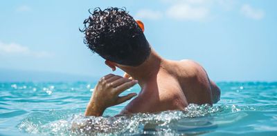 How can I get water out of my ear after swimming?