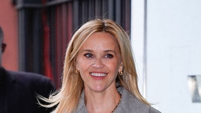 Reese Witherspoon's wide-leg jeans, striped shirt and brown jumper is the smart-casual formula I'm living in this January
