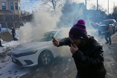 Crowd yells 'cowards!' after federal agents crash into a car and fire tear gas in Minneapolis