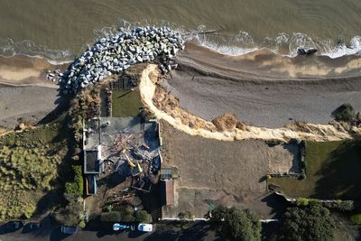 Aerial images show demolition of fourth clifftop home amid coastal erosion