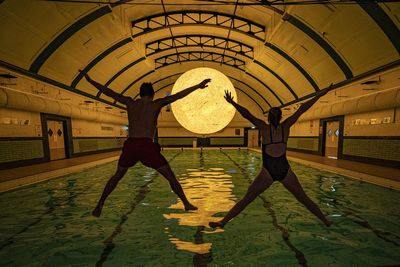 Sun artwork suspended above water at community swimming pool