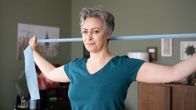 If you work at a desk, a Pilates teacher recommends these three yoga strap moves to loosen up hunched shoulders