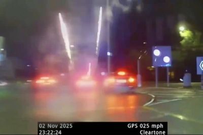 Moment driver launches fireworks from car window during police chase down busy road