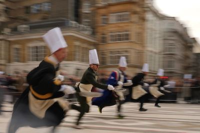 Photos of Londoners in costume sprinting with frying pans on Pancake Day