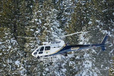 A helicopter heads into California’s Sierra Nevada as crews battle brutal conditions to recover 8