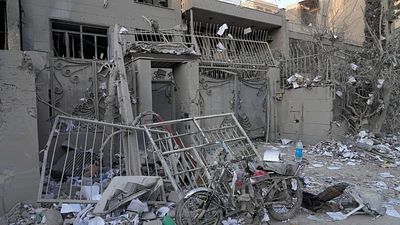 Workers clear rubble after US-Israeli strikes damage buildings in Tehran