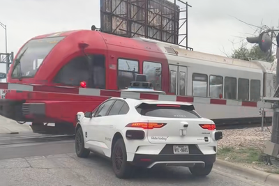Terrifying moment Waymo stops between railway tracks and stop arm as train passes by inches away