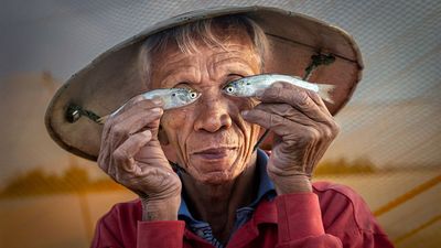 This amateur photographer beat 14,500+ entries to win top prize with this playful portrait of a Vietnamese fisherman