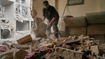 Residents clear rubble after strike damages buildings in southern Tehran