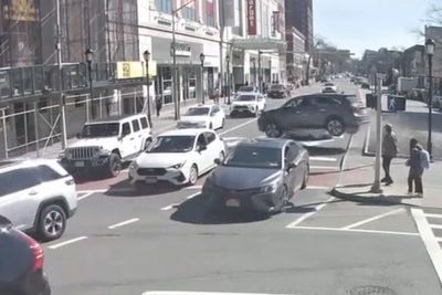 Close call for pedestrians as out-of-control car flies over busy junction in New York