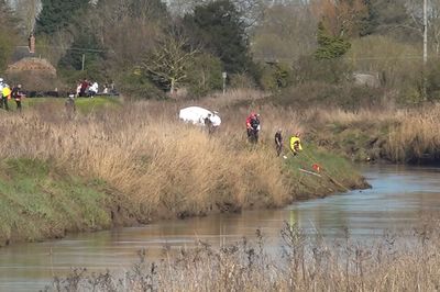 Body of teenage girl recovered after car plunged into river as search continues for male