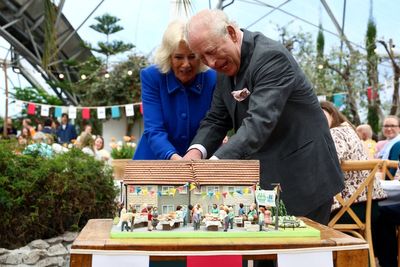 King and Queen share a giggle as they struggle to cut cake with sword